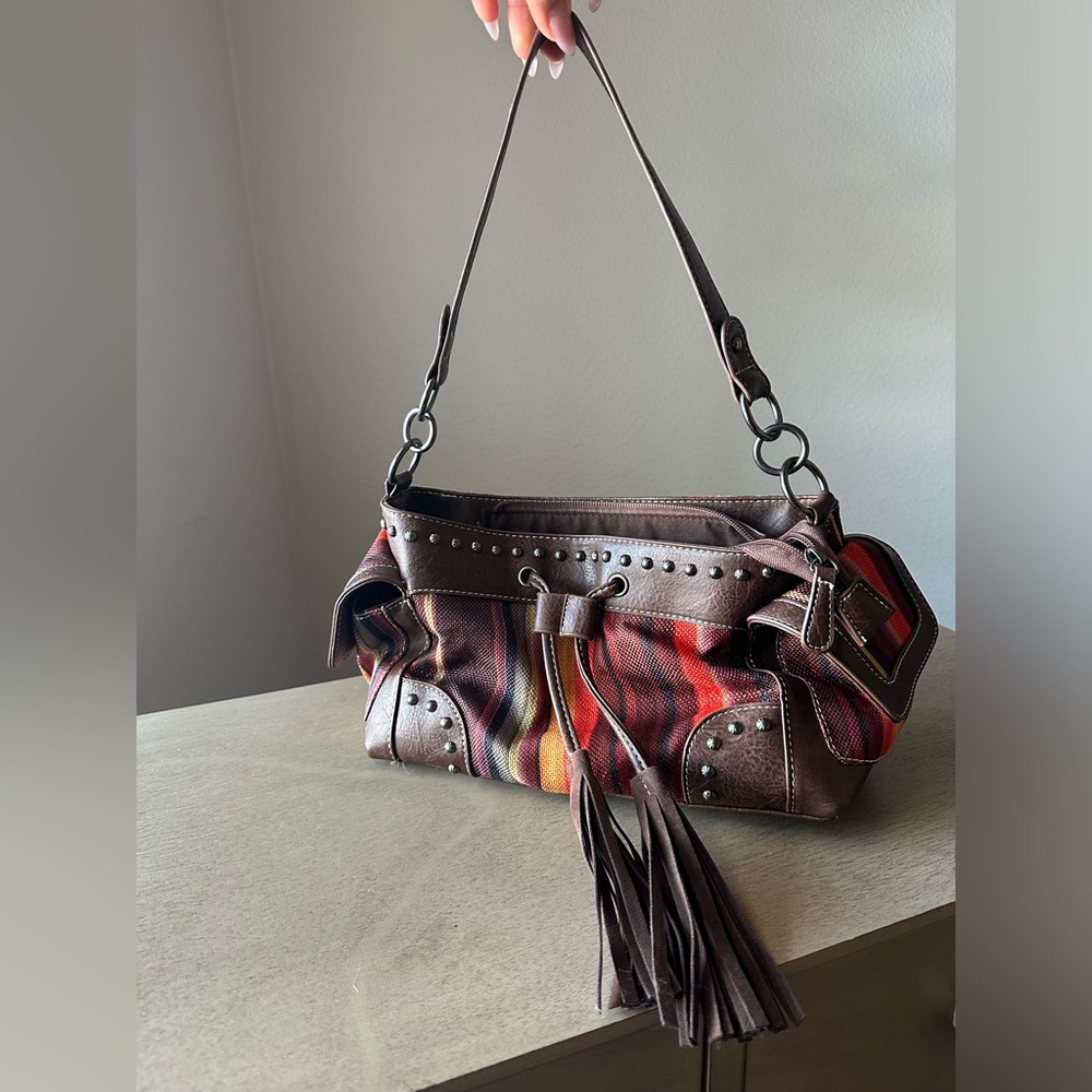 Brown and orange striped shoulder bag with tassels and zipper details